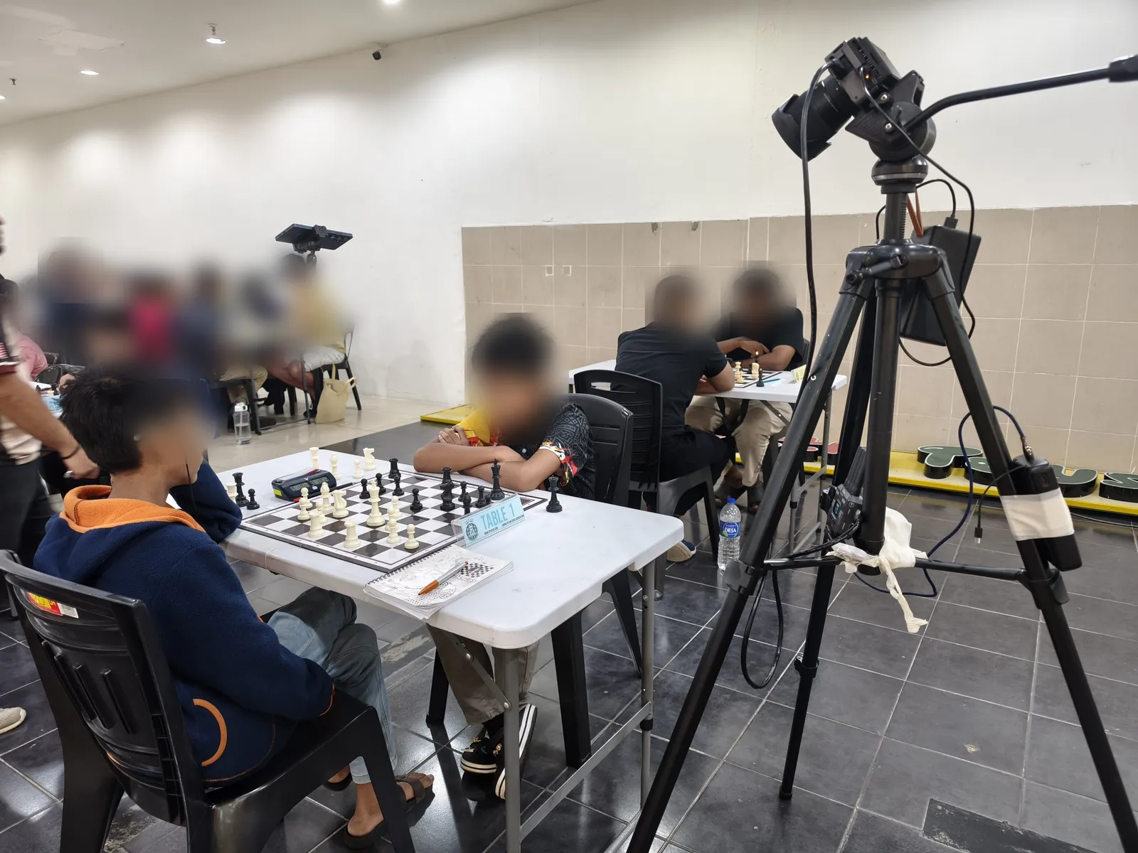 Tournament hall with a camera tripod filming Table 1