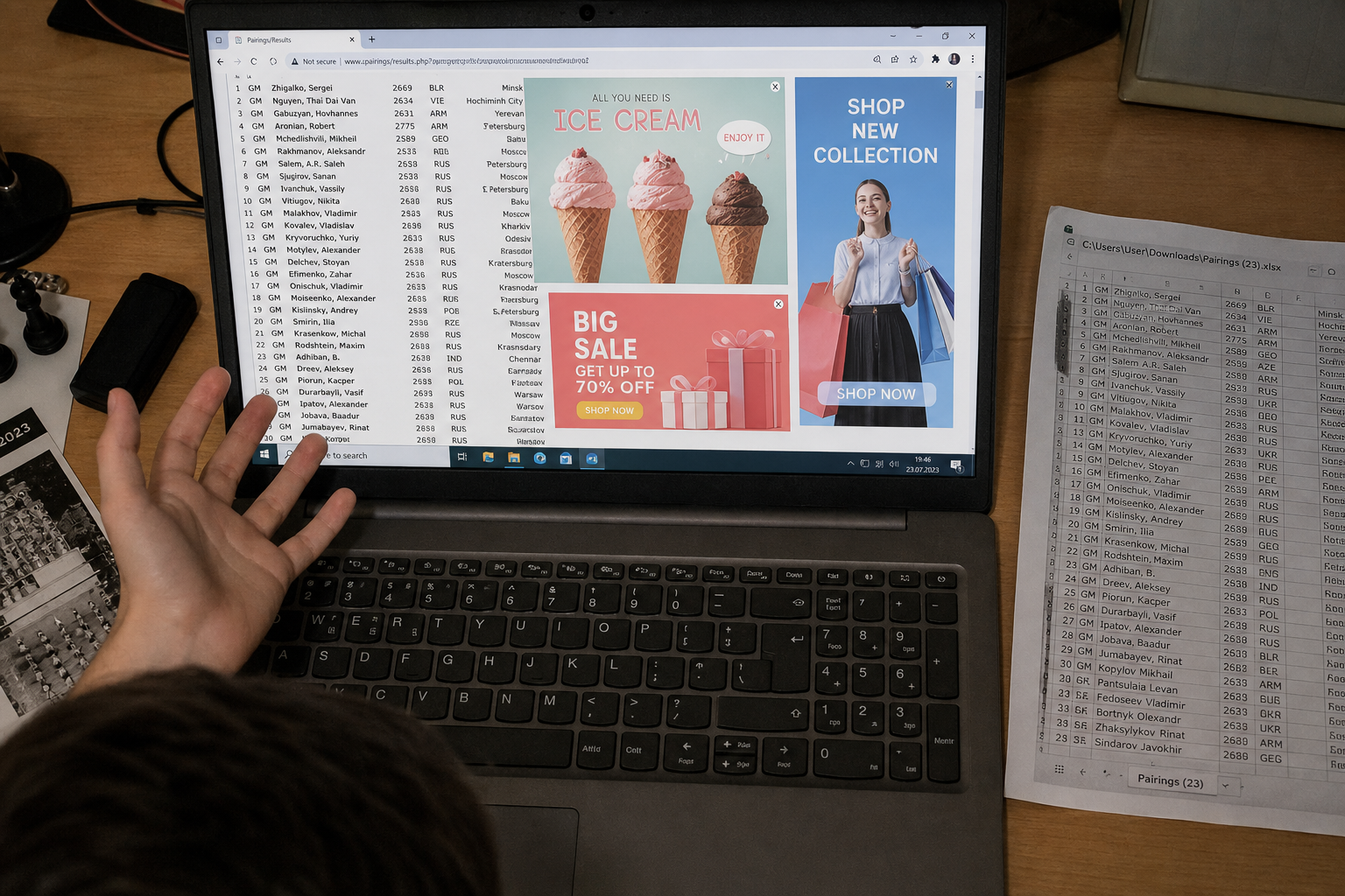 Laptop browser with popup ads covering a dense chess pairing table while a player looks frustrated